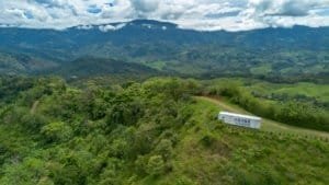 Lush green hills and mountains in Dominical, Costa Rica with a truck on the road.