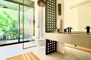 Contemporary bathroom with black and white design, large window, and natural light.