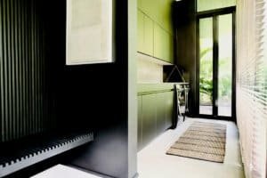 Contemporary laundry room with green cabinets and glass door in Dominical.