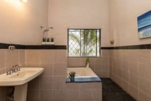 Bathroom with bathtub, sink, and window in Costa Rica property.