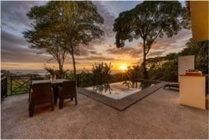 Beautiful ocean view villa with pool, sunset, and tropical trees in Dominical.