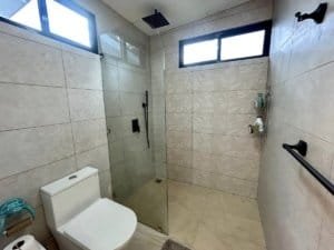Contemporary bathroom with walk-in shower, large windows, and modern fixtures.