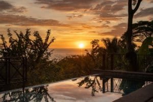 Beautiful ocean view sunset with pool and tropical foliage in Dominical, Costa Rica.