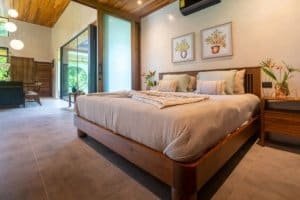 Spacious bedroom with wooden accents, tropical decor, and jungle views.