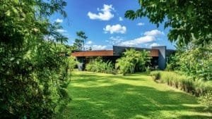 Modern luxury home surrounded by lush greenery and open lawn in Dominical.