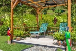 Outdoor garden with two lounge chairs, lush plants, and colorful decor in Dominical.