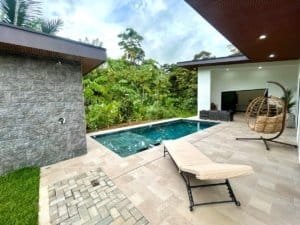 Luxury Costa Rican home with pool, outdoor lounge, and lush greenery.