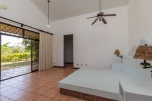 Bright living room with large sliding glass door and ceiling fan.