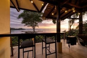 Balcony with ocean view, sunset, and tropical scenery in Dominical, Costa Rica.