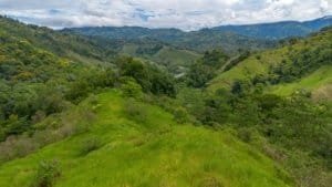 Lush green hills and valleys in Dominical, Costa Rica with mountains in the background.
