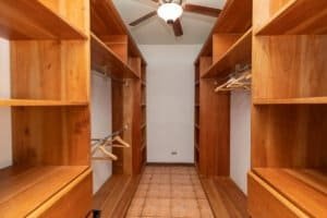 Large walk-in closet with wooden shelves and hanging space in Costa Rica.