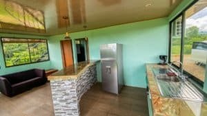 Interior of a kitchen with green walls, large window, and mountain scenery.