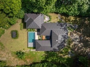 Aerial view of a Japanese-style home with pool surrounded by lush jungle in Dominical.