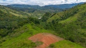 Lush green hills and a cleared plot of land in Dominical, Costa Rica.