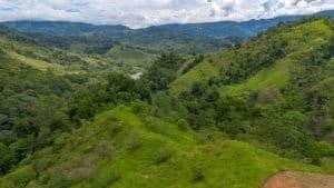 Lush green hills and valleys in Dominical, Costa Rica with cloudy sky.
