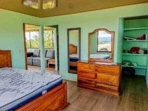 Interior of a bedroom with wooden furniture and mountain views in Costa Rica.