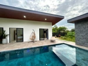 Contemporary tropical home with private pool and outdoor seating area.
