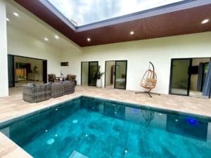 Luxury modern tropical home with private pool and outdoor seating area.