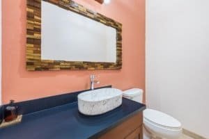 Contemporary bathroom with marble sink, mirror, and toilet in Costa Rica.