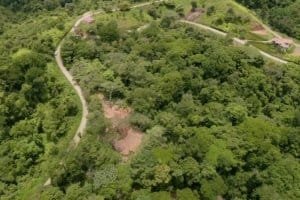 Aerial view of lush wildlife reserve with river and walking paths in Dominical.