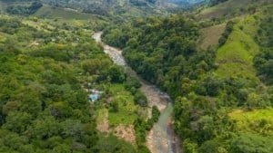 Lush green river valley in Dominical, Costa Rica with mountains in the background.