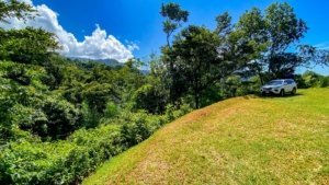 Quiet jungle landscape with a white car and mountain views in Dominical.