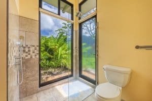 Bathroom with ocean view, glass door, shower, and toilet in Costa Rica.