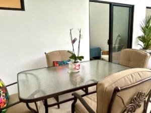 Interior view of a modern tropical home with a dining table and pool access.