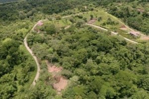 Aerial view of lush green wildlife reserve with winding roads in Dominical, Costa Rica.