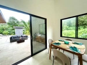 Interior view of a tropical home with dining area and outdoor pool in Dominical.