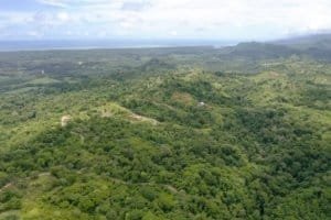 Lush green wildlife reserve with river and hills in Dominical, Costa Rica.