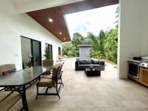 Spacious outdoor patio with seating, pool, and lush greenery in Dominical.