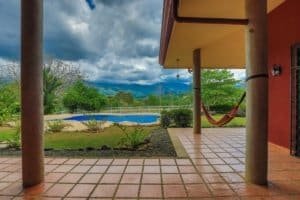 View of pool, hammock, and mountains in Dominical Costa Rica.