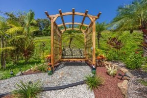Beautiful tropical garden with wooden swing and lush greenery in Dominical.