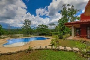 Beautiful backyard with pool, lush greenery, and mountain view in Dominical.