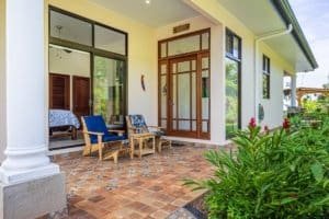 Outdoor patio of a luxury Costa Rica home with seating and garden view.