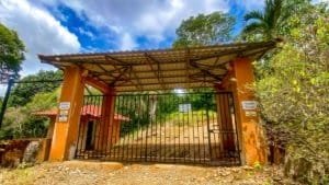 Gated entrance to a private jungle plot with building platforms and mountain views.