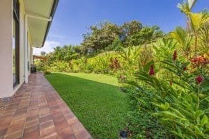 Lush tropical garden with patio and manicured lawn in Dominical, Costa Rica.