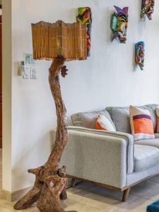 Decorative driftwood floor lamp with bamboo shade in modern living room setting.