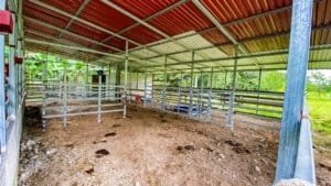 Covered riding arena with metal roof and fenced riding area in Dominical.
