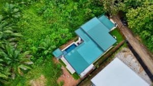Aerial view of a modern tropical home with private pool in lush surroundings.