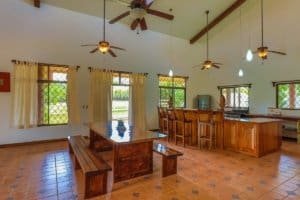 Interior of a hacienda style home with wooden furniture and ceiling fans.