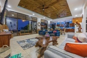Spacious living room with ocean view, modern furniture, and tropical decor.