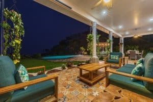 Night view of outdoor patio with seating, pool, and garden in Dominical.