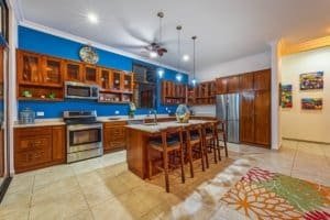 Modern kitchen with wooden cabinets, stainless steel appliances, and island in Dominical.