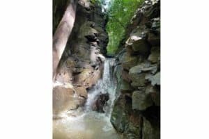 Scenic waterfall flowing through rocky canyon in Dominical, Costa Rica.