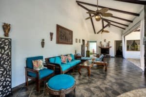 Spacious Bali style living room with blue furniture and tropical decor.