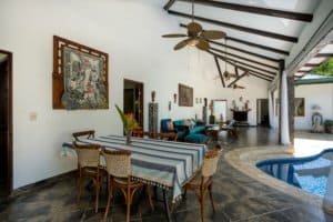 Open living area with high ceilings, tropical decor, and pool in Dominical.