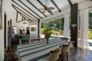 Bright living room with high ceilings, ceiling fans, and large windows in Dominical, Costa Rica.