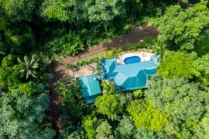 Aerial view of a Bali style home surrounded by lush green forest in Dominical.